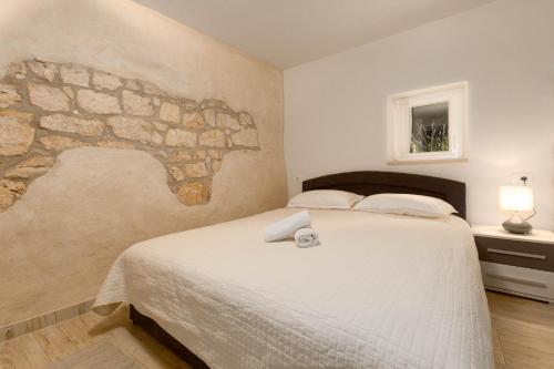 a bedroom with a large bed with a stone wall at Stancia Rosa - apartment Kiwi in Poreč