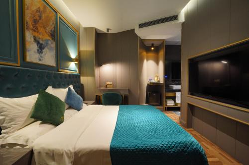 a hotel room with a bed and a flat screen tv at Mehood Hotel Shanghai Lujiazui in Shanghai