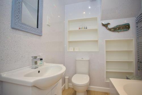 een witte badkamer met een wastafel en een toilet bij Chalet Fiftynine in Deal