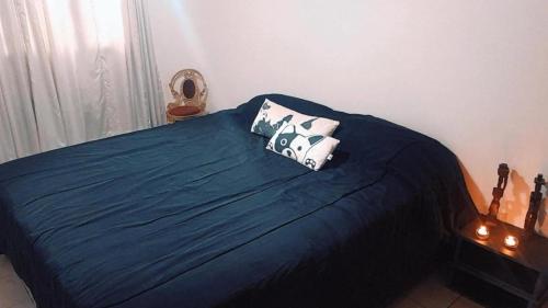 a bedroom with a bed with two pillows on it at Departamentos Parque Benegas in Godoy Cruz