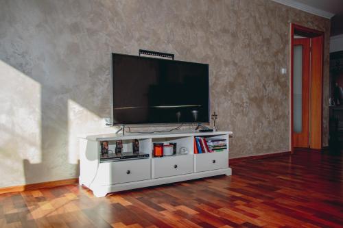 a white entertainment center with a flat screen tv at Contact Apartman in Bardejov