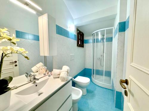 uma casa de banho azul e branca com um WC e um lavatório em Luigia House em Marina di Cerveteri