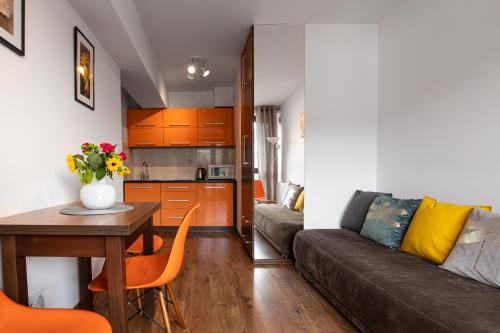 - un salon avec un canapé et une table dans l'établissement Aparthotel City Center Apartments, à Krynica-Zdrój