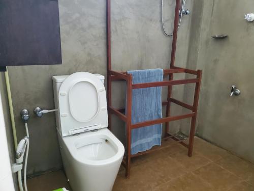 uma casa de banho com um WC e um toalheiro. em Hoxton Bay Surf House weligama em Weligama