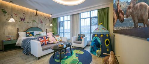 Habitación infantil con dormitorio con cama y zona de juegos. en Mehood Theater Hotel, Changzhou Dinosaur Park en Changzhou
