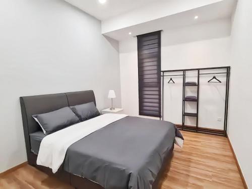 a bedroom with a large bed and a white wall at The Cove Hillside Residence Ipoh in Ipoh