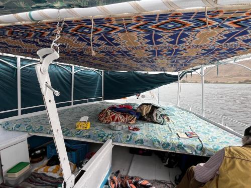 un cane che dorme sul ponte di una barca di Felucca Sailing Boat Overnight Experience a Aswan