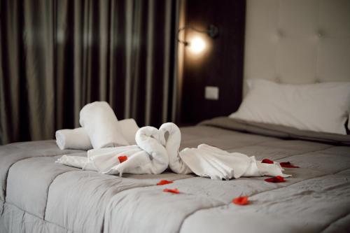 Una cama con toallas con forma de corazón. en BlueBay Residence Resort en Taranto