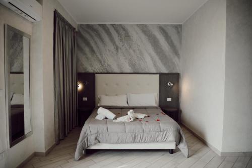 Un dormitorio con una cama con dos animales. en BlueBay Residence Resort en Taranto