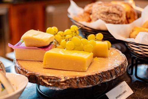 a plate of cheese and grapes and bread on a table at Urban by CityBlue Hotel, Dar es Salaam in Dar es Salaam