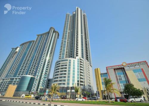 a group of tall buildings in a city at Luxury Home Corniche Tower 2 BHK pool gym wifi 20min Dubaï in Ajman 