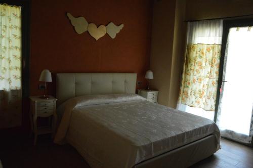a bedroom with a bed and two night stands and a window at B&B La Piazzetta in Castiglione dei Pepoli