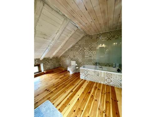 a bathroom with a tub and a wooden floor at Regalate Paz in Arguis