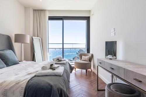 een slaapkamer met een bed en een bureau met een televisie bij Delmar Beachfront 2 Bedrooms Residence in Limassol
