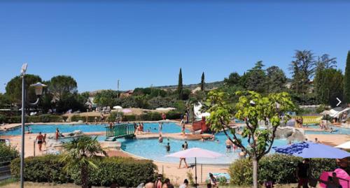 una gran piscina con gente en un complejo en Les Romarins, appartement impeccable et son parking privé, en Nyons