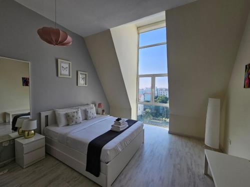 a bedroom with a large bed and a large window at Vibrant,affordable Apt 5 Minutes From Metro in Dubai