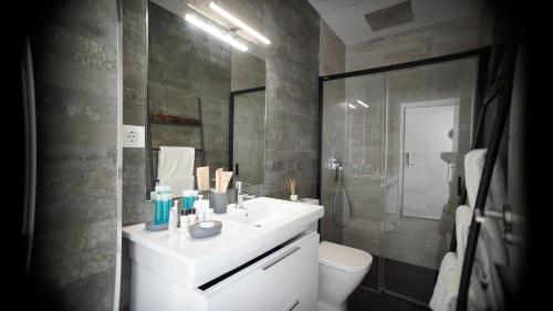 een badkamer met een wastafel, een toilet en een douche bij VILLA ANYWAY CONIL Un lujo frente al mar in Conil de la Frontera