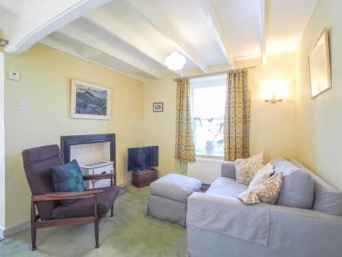 a living room with a couch and a chair and a television at Craiglea St Dogmaels in Saint Dogmaels