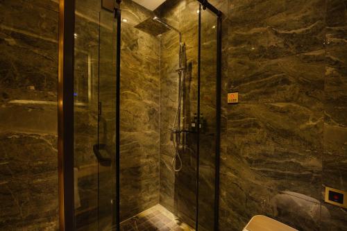a bathroom with a shower with a glass door at Mehood Hotel Shanghai Lujiazui in Shanghai