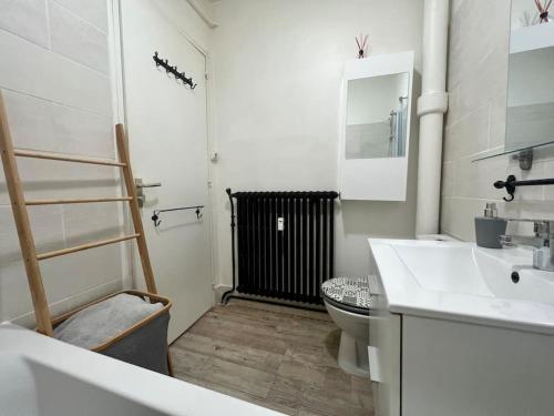 a white bathroom with a toilet and a sink at Le P'tit Anatole - Joli T2 avec parking in Poitiers