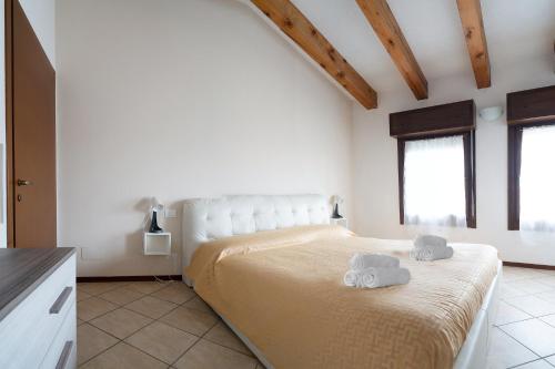 een slaapkamer met een groot bed en 2 handdoeken bij Le Dolci Mura Montagnana in Montagnana