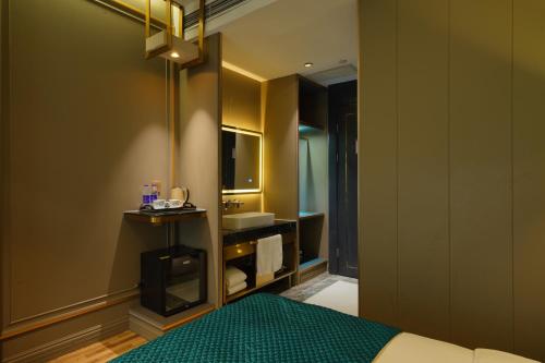 a bedroom with a bed and a sink and a mirror at Mehood Hotel Shanghai Lujiazui in Shanghai