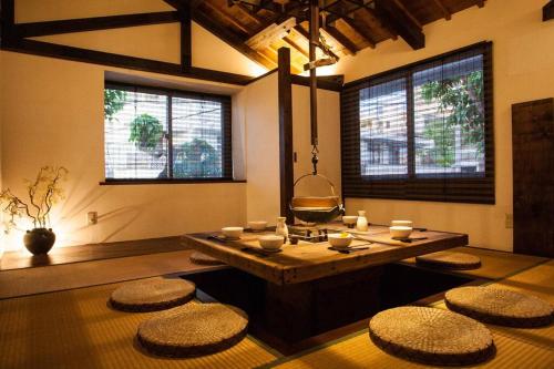 a living room with a table and stools in it at Classical Japanese style&Modern house Chill out囲炉裏 in Minatogawa