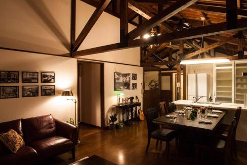 a living room with a table with chairs and a couch at Classical Japanese style&Modern house Chill out囲炉裏 in Minatogawa