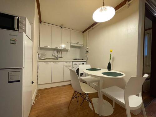uma cozinha com uma mesa e cadeiras e um frigorífico em La Tulipe em Seul