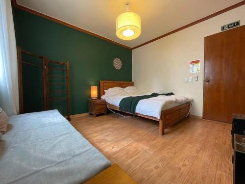 um quarto com 2 camas e uma parede verde em La Tulipe em Seul