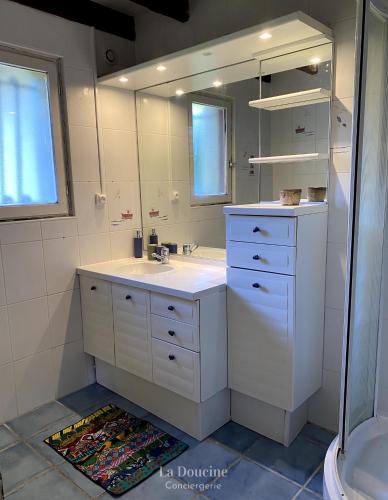 une salle de bain blanche avec un lavabo et un miroir dans l'établissement Maison de la forêt, à Arès