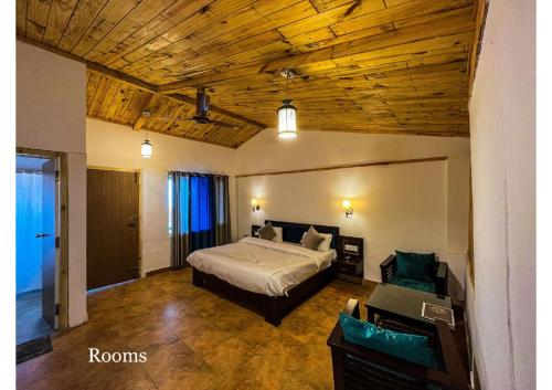 a bedroom with a bed and a wooden ceiling at Stoneshed Resort And Hotel in Nainital