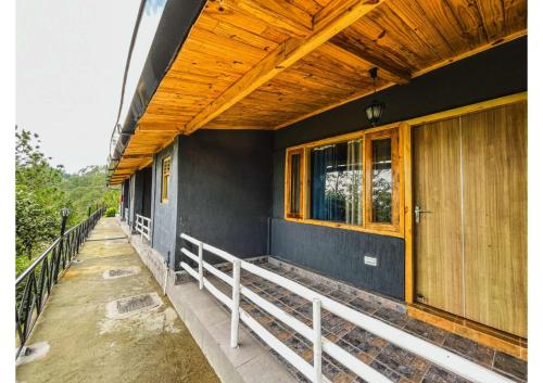 a building with a porch with a wooden roof at Stoneshed Resort And Hotel in Nainital