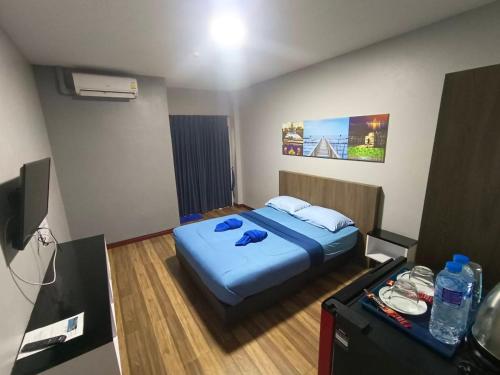 a bedroom with a bed with blue sheets on it at Chai Style Mansion in Ban Khlong Bang Bon