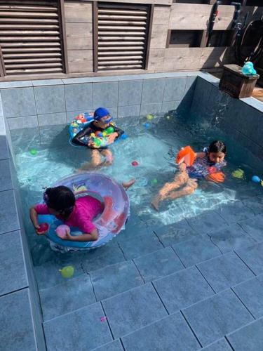 three children are playing in a swimming pool at Classical Japanese style&Modern house Chill out囲炉裏 in Minatogawa