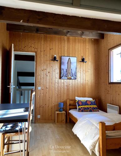 une chambre avec un lit dans un mur en bois dans l'établissement Maison de la forêt, à Arès