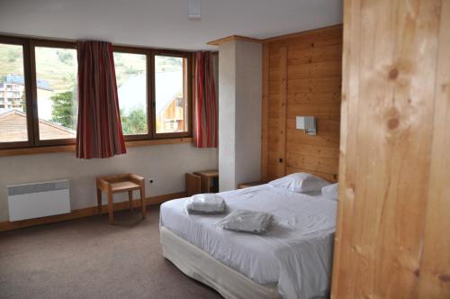 une chambre avec un lit avec deux serviettes dessus dans l'établissement Cortina - 21 - Appart belle vue - 8 pers, à Les Deux Alpes