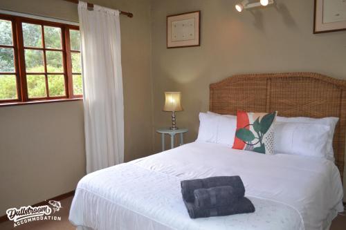 um quarto com uma cama branca e uma toalha azul em Forest Vista em Dullstroom