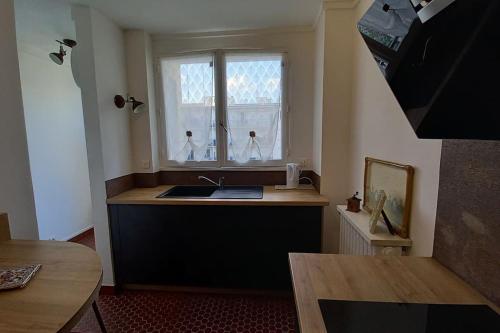 une cuisine avec un évier et une fenêtre dans l'établissement L'ESCUDIER Appartement calme proche Rolland Garros avec vue panoramique et parking, à Boulogne-Billancourt