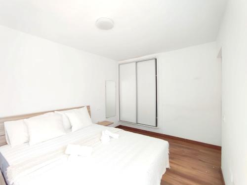 ein weißes Schlafzimmer mit 2 Betten und einem Fenster in der Unterkunft Pozo Wave Properties in Pozo Izquierdo
