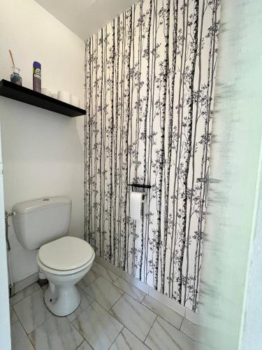 La salle de bains est pourvue de toilettes et de papier peint noir et blanc. dans l'établissement Piet, à Sérignan