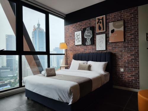 - une chambre avec un grand lit et un mur en briques dans l'établissement Scarletz KLCC By Starwood Lux, à Kuala Lumpur