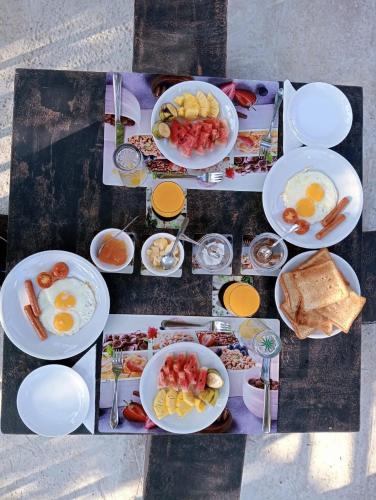 a table with plates of breakfast food on it at Power Zone Guest House in Matale