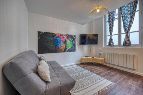 ein Wohnzimmer mit einem Sofa und einem Gemälde an der Wand in der Unterkunft Le Charreton 1 I Ile Verte / CHU de Grenoble in Grenoble