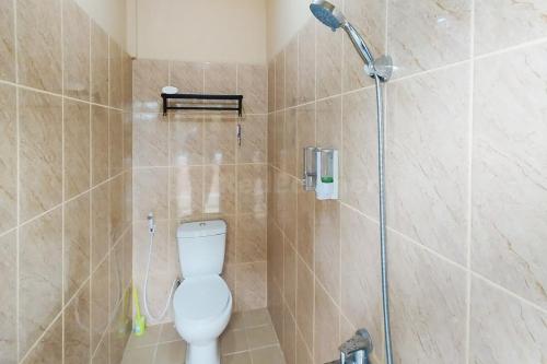 uma casa de banho com um WC branco e um chuveiro em Arwana Inn Lampung RedPartner em Bandar Lampung