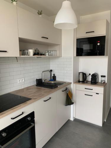 une cuisine avec des armoires blanches et un évier dans l'établissement Appartement 50m2 Caen, à Caen