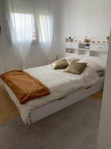 une chambre blanche avec un grand lit avec une fenêtre dans l'établissement Appartement 50m2 Caen, à Caen
