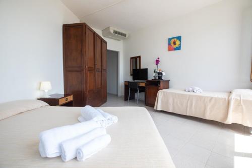 a hotel room with two beds and a desk at Hotel De Plam in Olbia