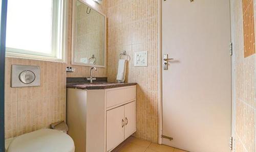 古爾岡的住宿－TIPSYY INN 020，一间带卫生间、水槽和镜子的浴室