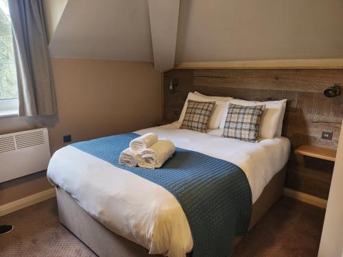 a bedroom with a large bed with towels on it at The Oak Baginton in Coventry